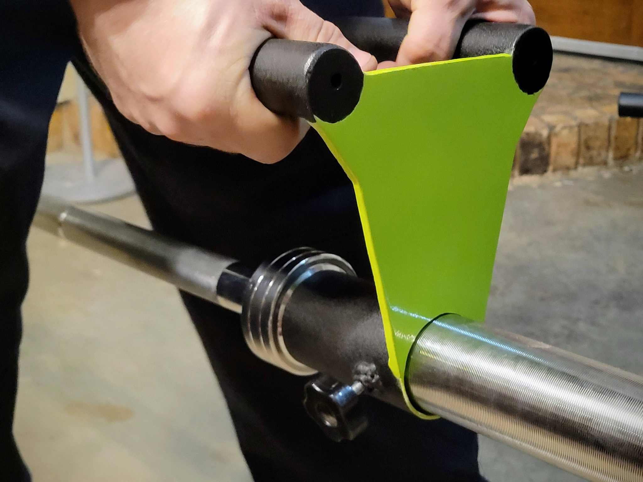 User installing Narrow Parallel Grip Barbell Handle onto Olympic barbell, showcasing secure fit for landmine exercises and gym setups.